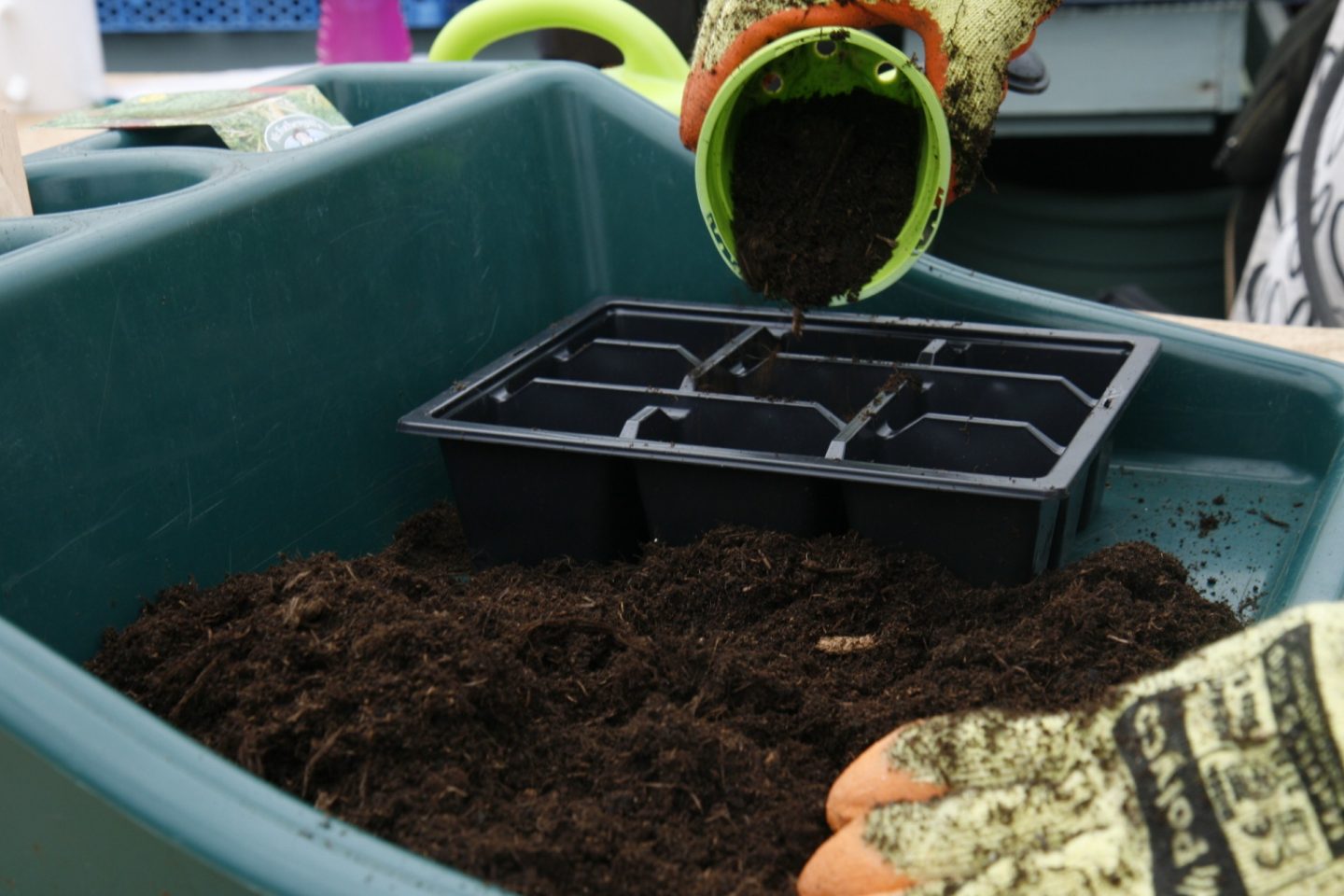 Compost being added into tray using a small flowerpot