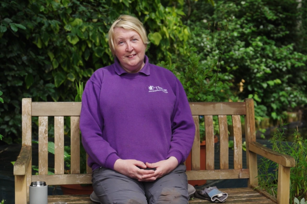 Client Gardener Lisa on bench in the garden at Thrive Birmingham