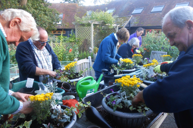 Client gardeners planting flowers in pots